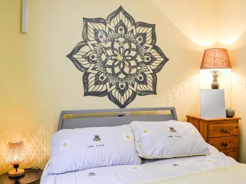 a bedroom with a bed with a mandala on the wall at Two Peas In A Pod in Henfynyw Upper