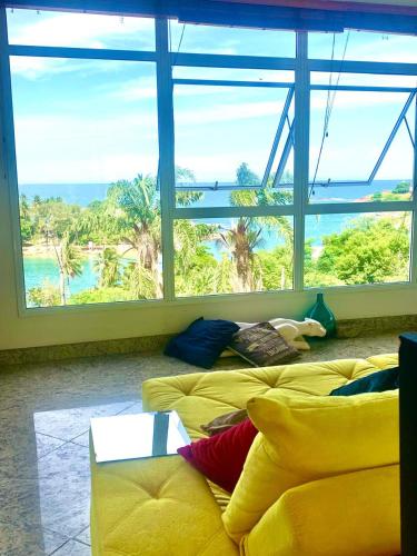 a room with two yellow beds and a large window at Sonho do Moreno in Vila Velha