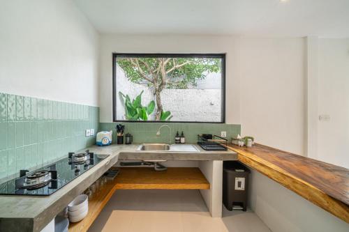 a kitchen with a sink and a window at Nyma Villa in Seminyak