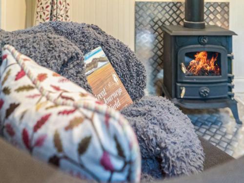 a bed with a book and a stove at Jacobs Folly-Qu7115 in Melton Constable