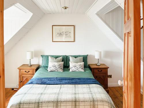 a bedroom with a green bed with two night stands at The Fisherman's Cottage in Applecross