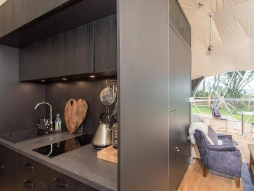 a kitchen with black cabinets and a counter top at Gwenllian in Machynlleth