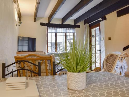 ein Esszimmer mit einem Tisch mit einer Vase in der Unterkunft Ivory Cottage in Woolacombe
