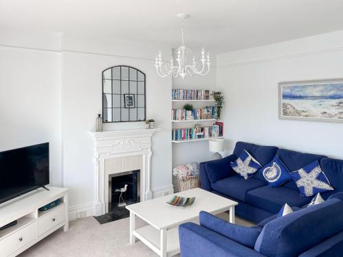 a living room with a blue couch and a fireplace at Anchor Loft in Fowey