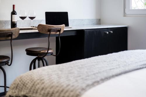 a bedroom with a desk with a laptop and glasses of wine at Apart Hotel B in Santiago