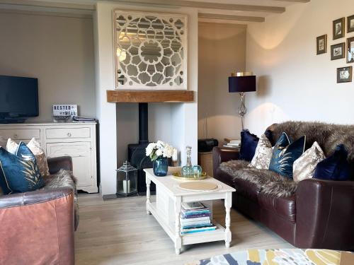 a living room with two couches and a fire place at Restwell in Mundesley