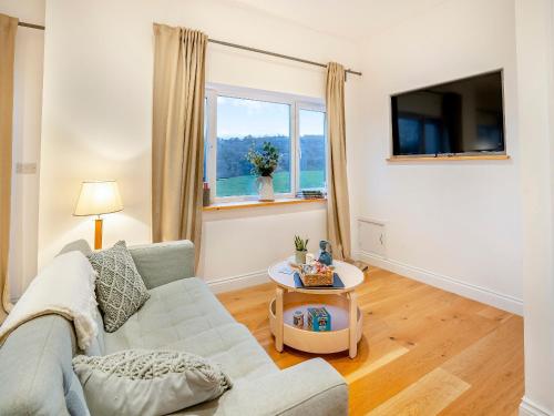 a living room with a couch and a tv at Bay Cottage in Tondu