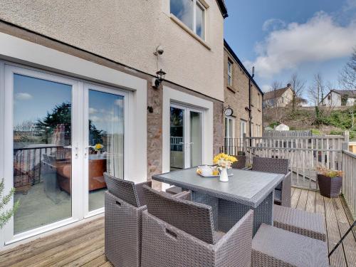 a patio with a table and chairs on a deck at The Old Forge - Muz in Wooler