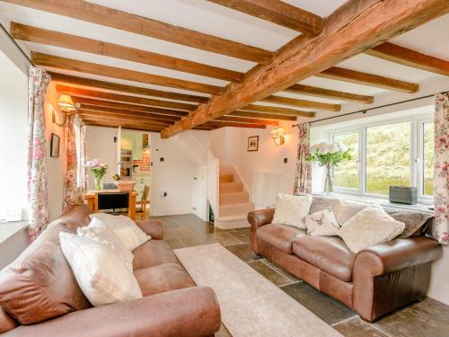 a living room with leather furniture and windows at Eton Cottage in Farnham
