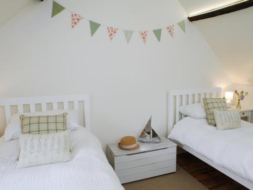 two white beds in a room with flags on the wall at Pemberly in Winchester
