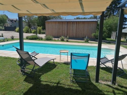 two chairs and a table next to a swimming pool at Gîte Ecureuil avec piscine 4-6 personnes in Villeloin-Coulangé