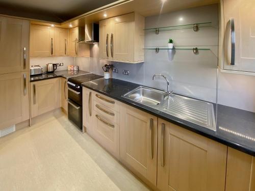 a kitchen with wooden cabinets and a sink at Broad Apartment 8 - Uk48084 in Kirkwall