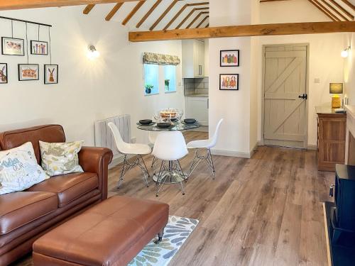 a living room with a couch and a table at Hop Cottage in Sellindge
