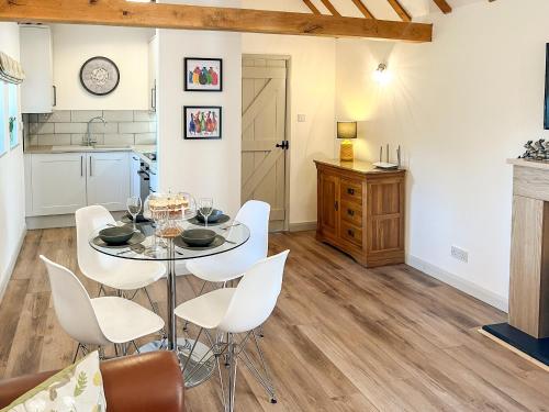 a kitchen and dining room with a table and chairs at Hop Cottage in Sellindge