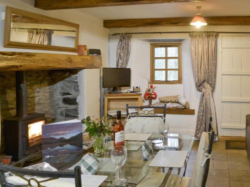 a living room with a table and a fireplace at St Francis Cottage in Seathwaite