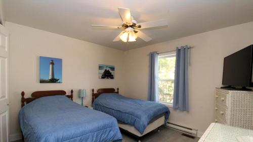 a bedroom with two beds and a ceiling fan at 149 Emerald Avenue in West Cape May