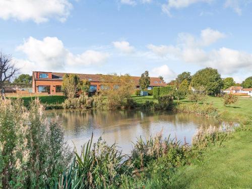 a building next to a pond in front of a building at Cottage 5 - Uk38221 in Ashby cum Fenby