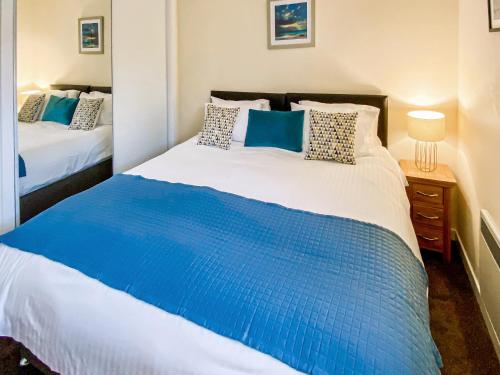 a bedroom with a large blue and white bed at Gairsay - Uk48092 in Kirkwall