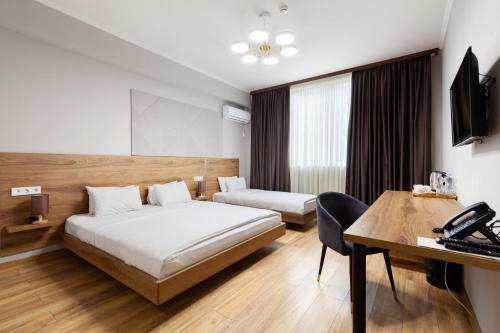 a hotel room with a bed and a desk at Gelati Residence in Kutaisi