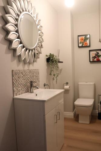 a bathroom with a sink and a mirror on the wall at Last-Minute Escape l The Grey Door 2 Bed Cottage Banbridge Parking Private Garden l Nestled Property Management in Banbridge