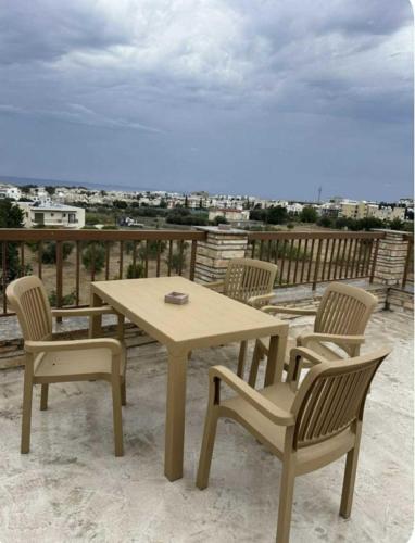 a wooden table and chairs on a balcony with a view at Stellas superior home in Paphos City
