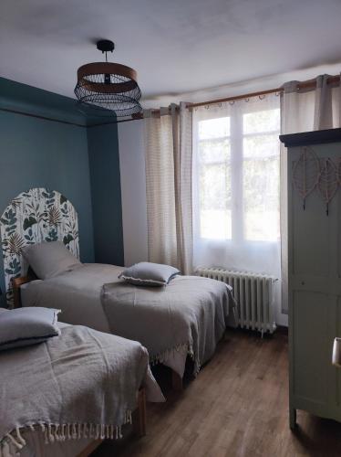 Un dormitorio con dos camas y una ventana. en La maison "Ty Lichoux", en Plouha