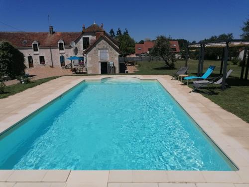 a swimming pool in front of a house at Gîte Hibou avec piscine 4-6 personnes in Villeloin-Coulangé