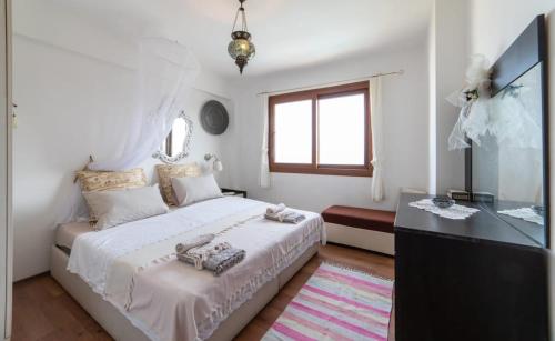 a white bedroom with a bed and a window at Villa Selen in Bogazici