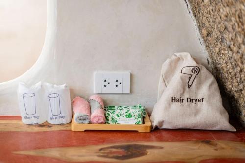 a counter with a hair dryer and a light switch at The Rock Samui Beachfront Villas - Sha Plus Hotel in Lamai