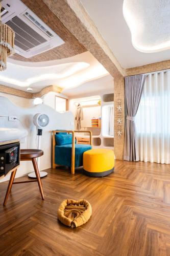 a room with a bed and a table and a yellow chair at The Rock Samui Beachfront Villas - Sha Plus Hotel in Lamai