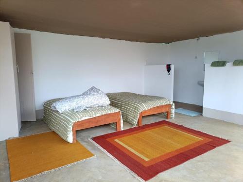 a living room with a couch and two rugs at Mara Moon cottages in Sekenani