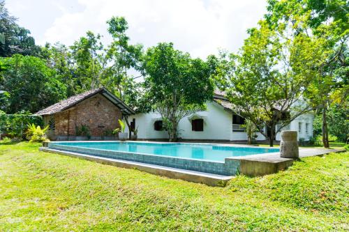 a swimming pool in front of a house at Villa Kobeimalhéna, Matara in Sulutanagoda