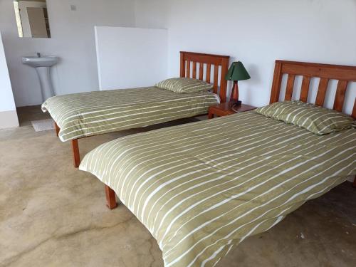 two beds sitting next to each other in a room at Mara Moon cottages in Sekenani