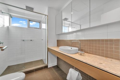 Un baño con lavabo, ducha e inodoro. en Waterfront Stay with Marina Views and Easy CBD Access, en Glanville