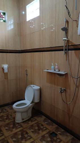 a bathroom with a toilet and a shower at Moon view Bungalow's in Kelimutu