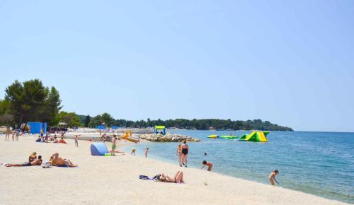 a group of people on a beach near the water at Apartment in Stinjan - Istrien 8432 in Štinjan