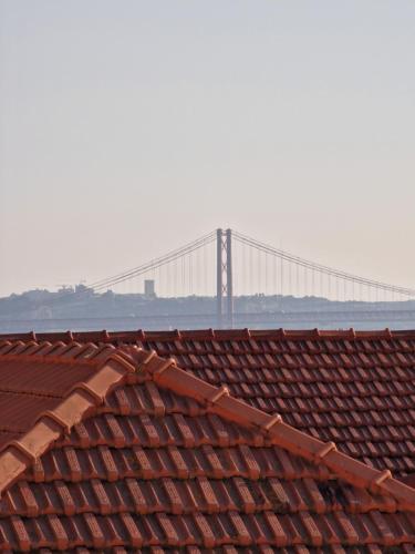 un puente al fondo con tejados rojos con un puente al fondo en Casa do Castelo, en Lisboa