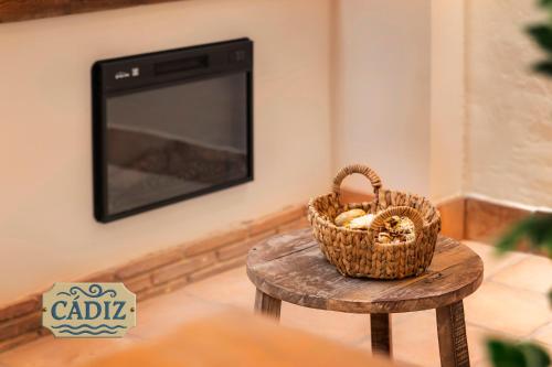 a basket on a table next to a tv at Mi Andalusia Hotel Experience in Málaga