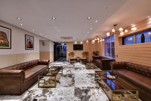 a lobby with leather couches and a table at RnB Select Walk Inn Lucknow in Lucknow