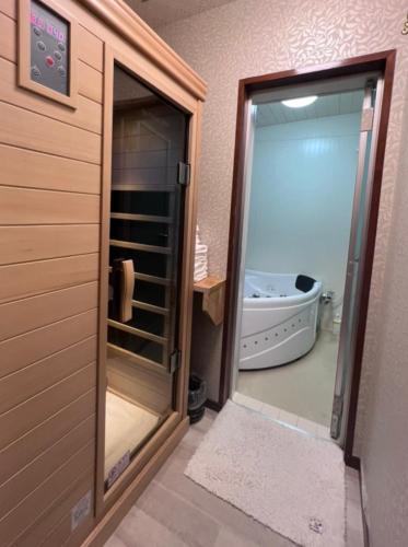 a bathroom with a glass door leading to a tub at Fuji-Kawaguchiko - Diamond Yu in Fujikawaguchiko