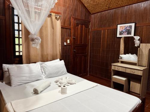 a bedroom with a bed with a table and a mirror at Victordelia Hilltop Hostel in San Vicente