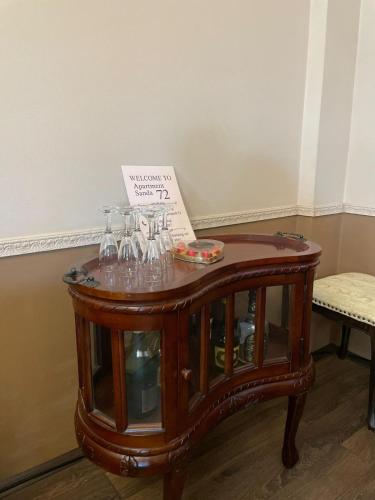 a table with wine glasses and a sign on it at Apartment Sanda 72 in Gevgelija