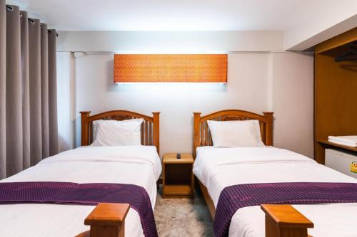two beds in a hotel room with twothirdsessions at GO INN Khaosan - โกอินน์ ถนนข้าวสาร in Bang Bua Thong Railway Station