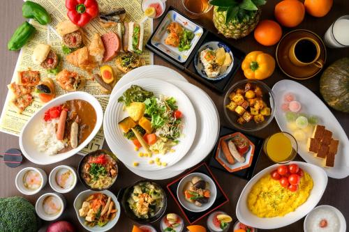 a table topped with plates of food and bowls of food at HOTEL FORZA HAKATA-GUCHI in Fukuoka