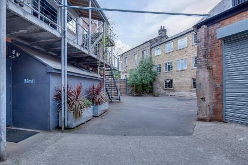 an empty parking lot next to a building with a staircase at Kelham 2 Bed Loft - Free Parking in Midland