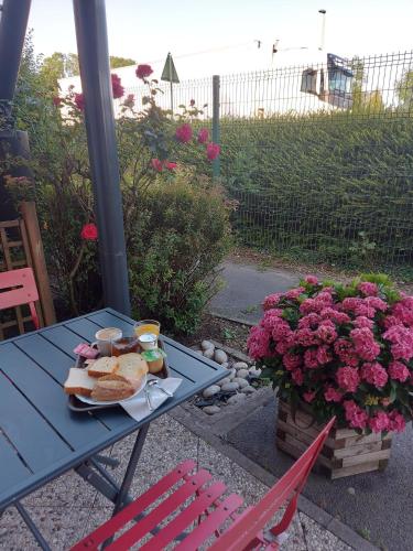 a picnic table with a plate of food and flowers at Premiere Classe Arras - Tilloy Les Mofflaine in Tilloy-lès-Mofflaines