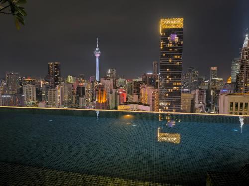 a view of a city skyline at night with a pool at Axon Residence Near Fehrenheit Bukit Bintang in Kuala Lumpur