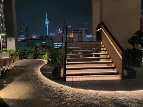 a set of stairs with a view of the city at night at Axon Residence Near Fehrenheit Bukit Bintang in Kuala Lumpur
