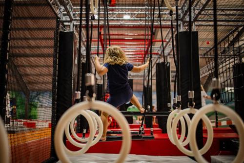a woman is on the rings in a gym at Thermenhotel Vier Jahreszeiten in Lutzmannsburg