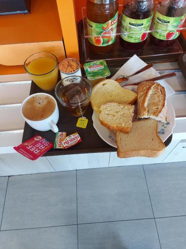 a tray with a plate of bread and a cup of coffee at Premiere Classe Arras - Tilloy Les Mofflaine in Tilloy-lès-Mofflaines